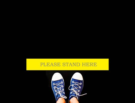 social distancing concept foot wearing sneakers and woman wearing high heelsの写真素材