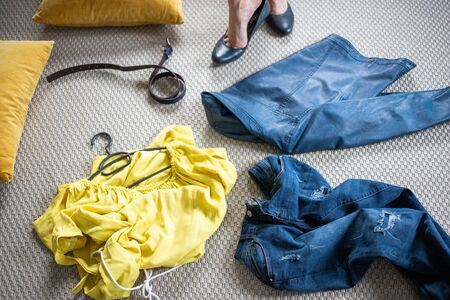 yellow and blue pieces of clothes on the floor woman undressing