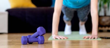woman doing exercise at home stay fit indoors focus on dumbells