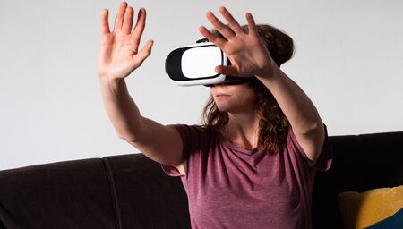 woman wearing virtual reality VR glasses at home