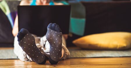 woman feet relaxing at home with laptopの写真素材