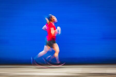 blurred image of woman jogging in a red shirt - healthy lifestyleの写真素材