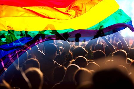 silhouette of a parade of gays and lesbians with a rainbow flag - symbol of love and toleranceの写真素材