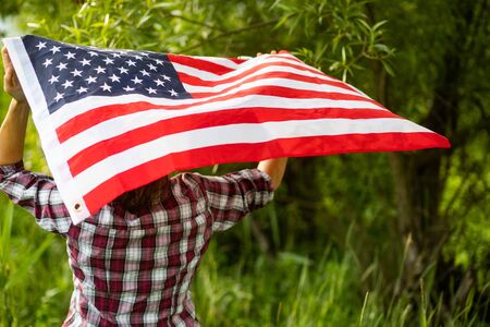 woman holding US flag independence day の写真素材