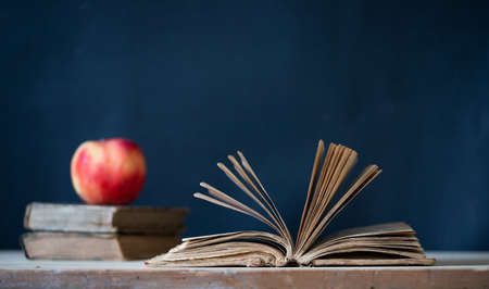 back to school concept pile of books against chalkboard