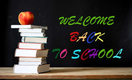 back to school concept pile of books against chalkboardの写真素材