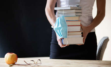 back to school during covid pandemic pile of books and medical maskの写真素材