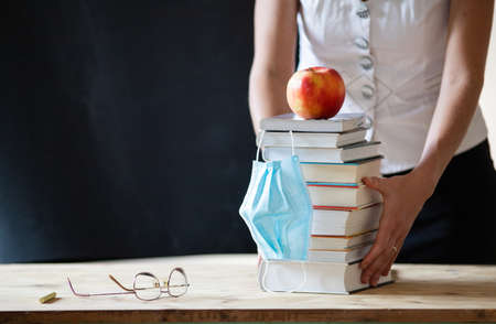 back to school during covid pandemic pile of books and medical maskの写真素材