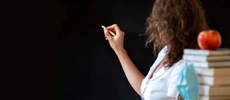 back to school concept pile of books against chalkboardの写真素材