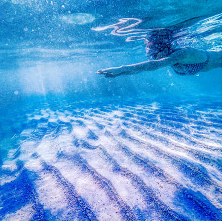 woman swimming in clear tropical waters - active holidayの写真素材