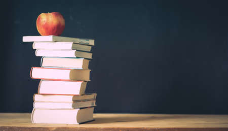 back to school concept pile of books against chalkboardの写真素材