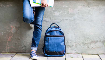 school kid feet in jeans backpack and mask back to school during pandemicの写真素材