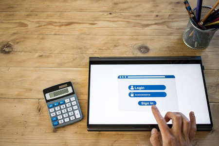 online apps hand pressing sign in button on tabletの写真素材