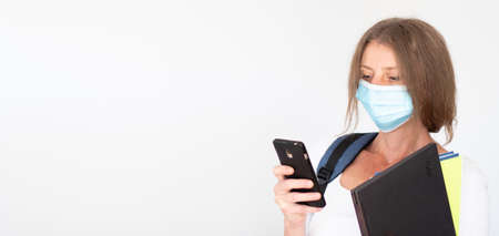 woman with mask laptop and notebooks