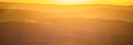 rolling hills in autumn sunset nature backgroundの写真素材