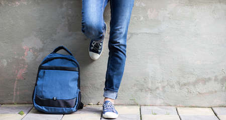 school kid feet in jeans and sneakers backpack  back to schoolの写真素材