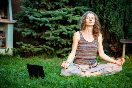 woman doing yoga in green backyardの写真素材