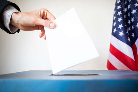 hand putting vote in ballot USA electionsの写真素材