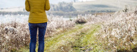 woman walking alone in autumn landscape  social distancing