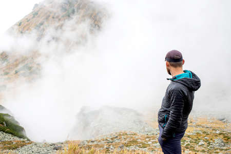 handsome male hiker in foggy mountains social distancingの写真素材