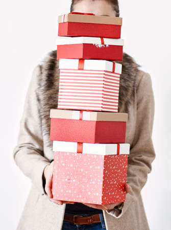 woman returning home from shopping holding pile of christmas present boxes
