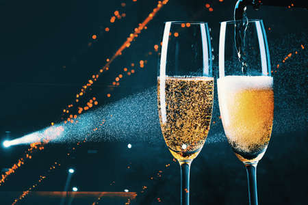 two glasses of champagne and holiday lights - new year celebration