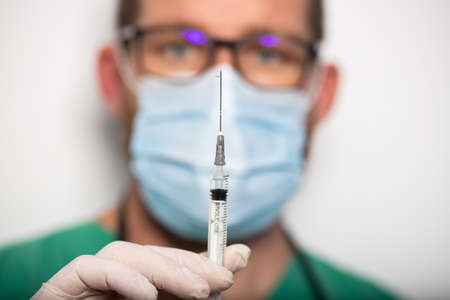 doctor holding covid - 19 coronavirus vaccine