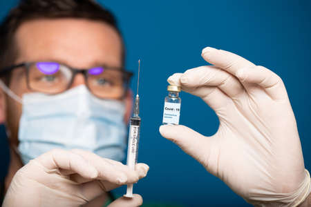 doctor holding covid - 19 coronavirus vaccine