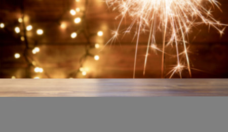 empty wooden desk space and Christmas lights in the background