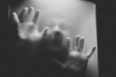 scary picture of hands behind glassの写真素材