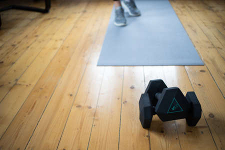 woman doing exercise at home focus on dumbellsの写真素材