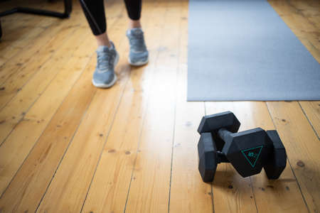 woman doing exercise at home focus on dumbells