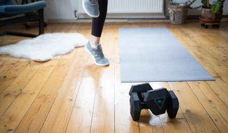 woman doing exercise at home focus on dumbellsの写真素材
