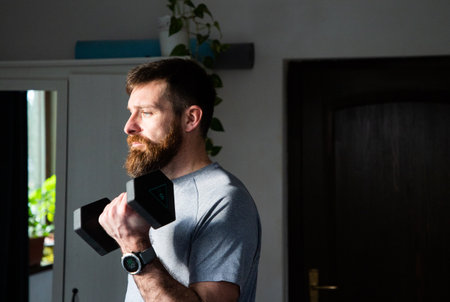 handsome man exercising at home lifting weights