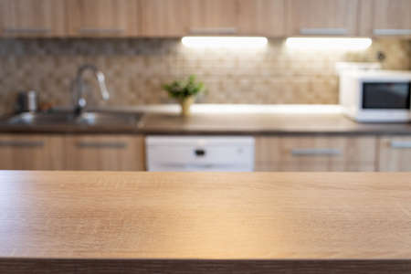 blurred kitchen interior and wooden desk space home backgroundの写真素材