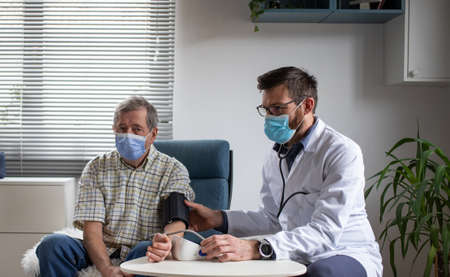 doctor consulting elderly male patient at homeの写真素材