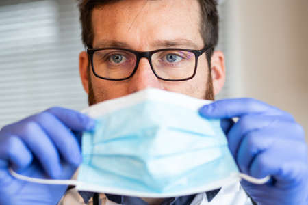 doctor putting on medical maskの写真素材