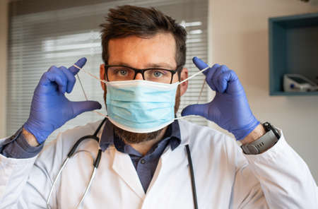 doctor putting on medical maskの写真素材