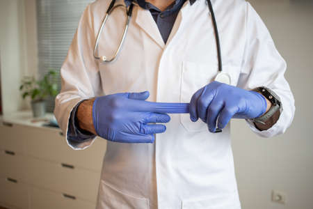 doctor taking off blue gloves