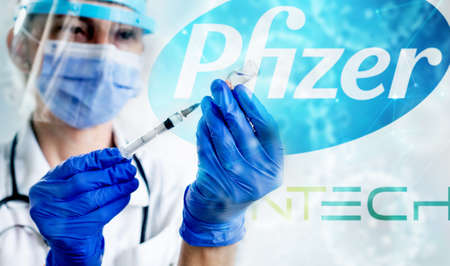 CLUJ-NAPOCA -ROMANIA - MARCH 9 2021: Pfizer vaccine Covid-19 concept. Syringe needle and vaccine,...