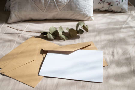 blank greeting card  invitation mockup with craft paper envelope  feminine still life compositionの写真素材