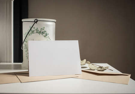 blank greeting card  invitation mockup with craft paper envelope  feminine still life compositionの写真素材
