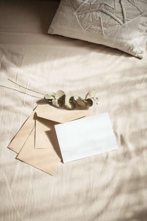 blank greeting card  invitation mockup with craft paper envelope  feminine still life compositionの写真素材