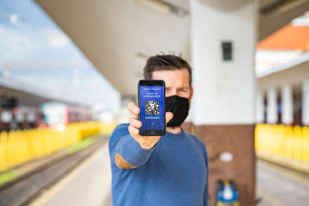 health Vaccine Passport for Coronavirus or Covid-19. Traveller Using Mobile Phone with Vaccination in Immune Status to Certificated International Traveling in train stationの写真素材