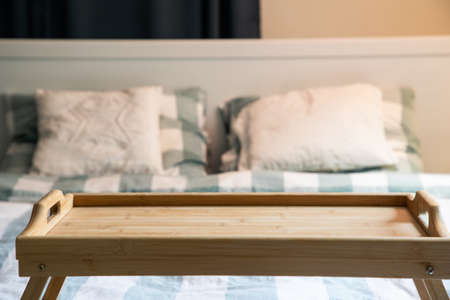 cozy bedroom detail focus on wooden breakfast tabletopの写真素材