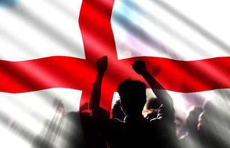 football fans supporting England - crowd celebrating in stadium with raised hands against England flagの写真素材