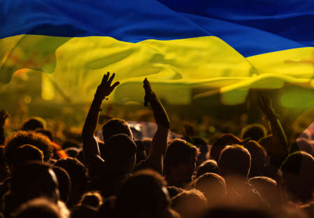 football fans supporting Ukraine - crowd celebrating in stadium with raised hands against Ukraine...