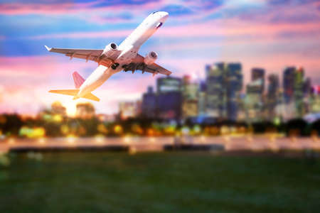 commercial plane taking off blurred city lights in the backgroundの写真素材