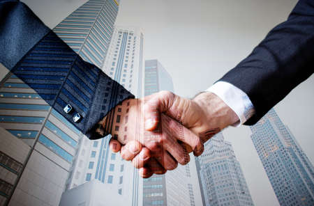 business collaboration double exposure of handshake and modern cityの写真素材