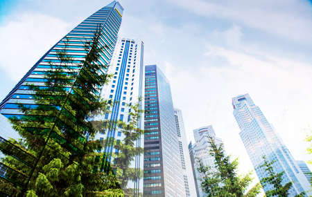 green city - double exposure of lush green forest and modern skyscrapers windowsのeditorial素材